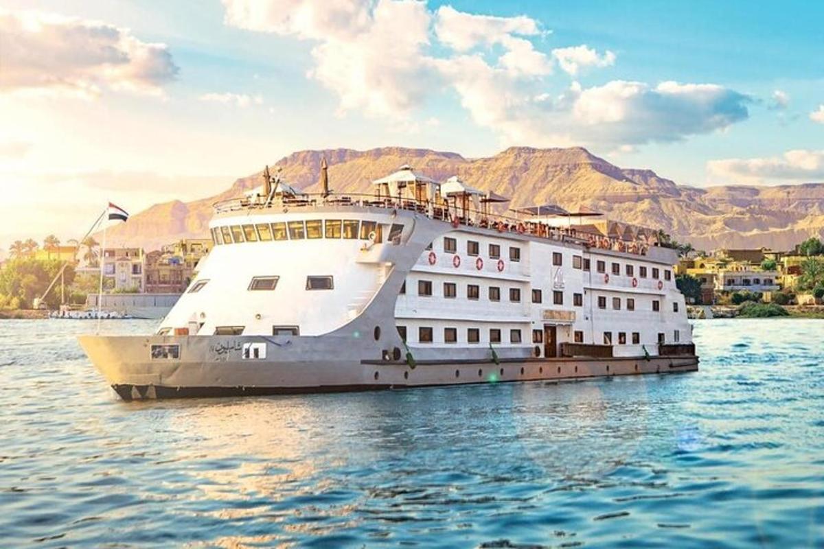 a cruise ship on the water with mountains in the background
