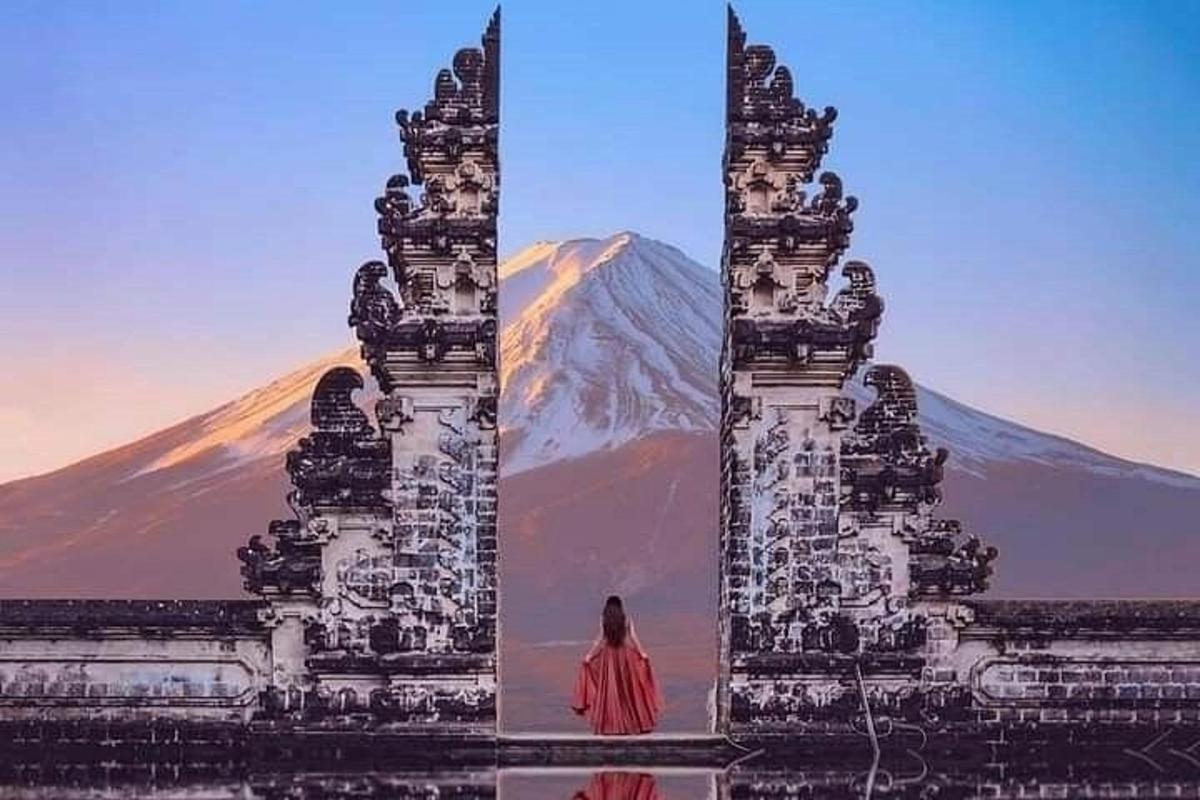 一位女士站在一座雕像前，背景是一座山