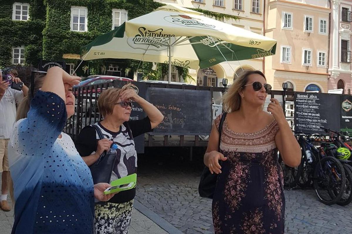 skupina lidí stojících na ulici pod deštníkem