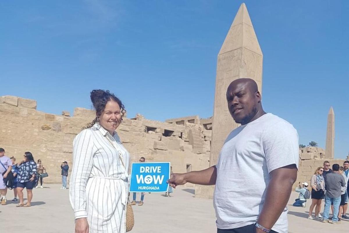 een man en een vrouw die een bord vasthouden voor een monument
