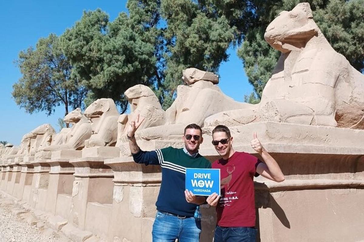 two men holding a sign in front of a statue