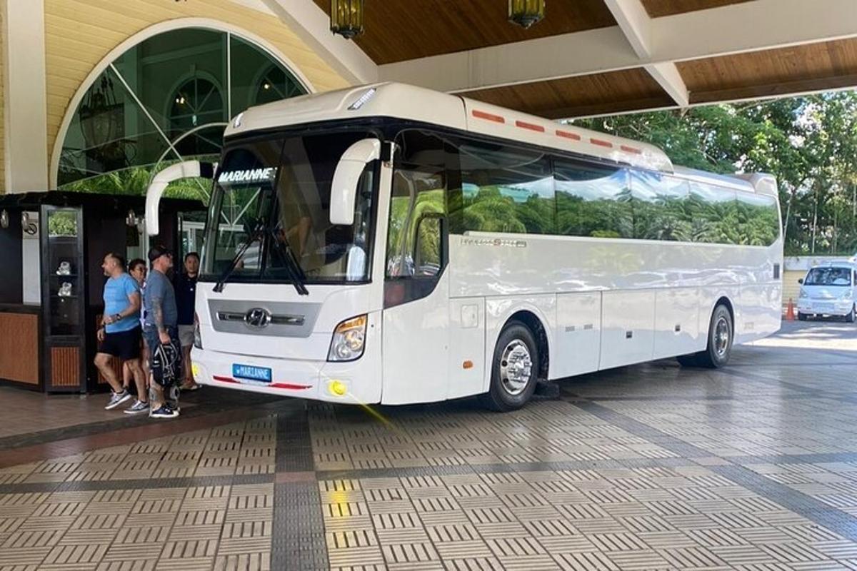 skupina lidí stojící vedle bílého autobusu