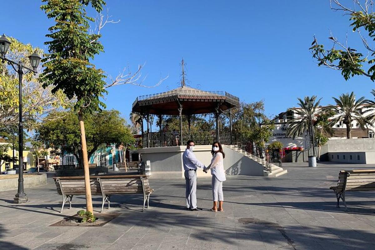 um homem e uma mulher de mãos dadas em frente a um mirante
