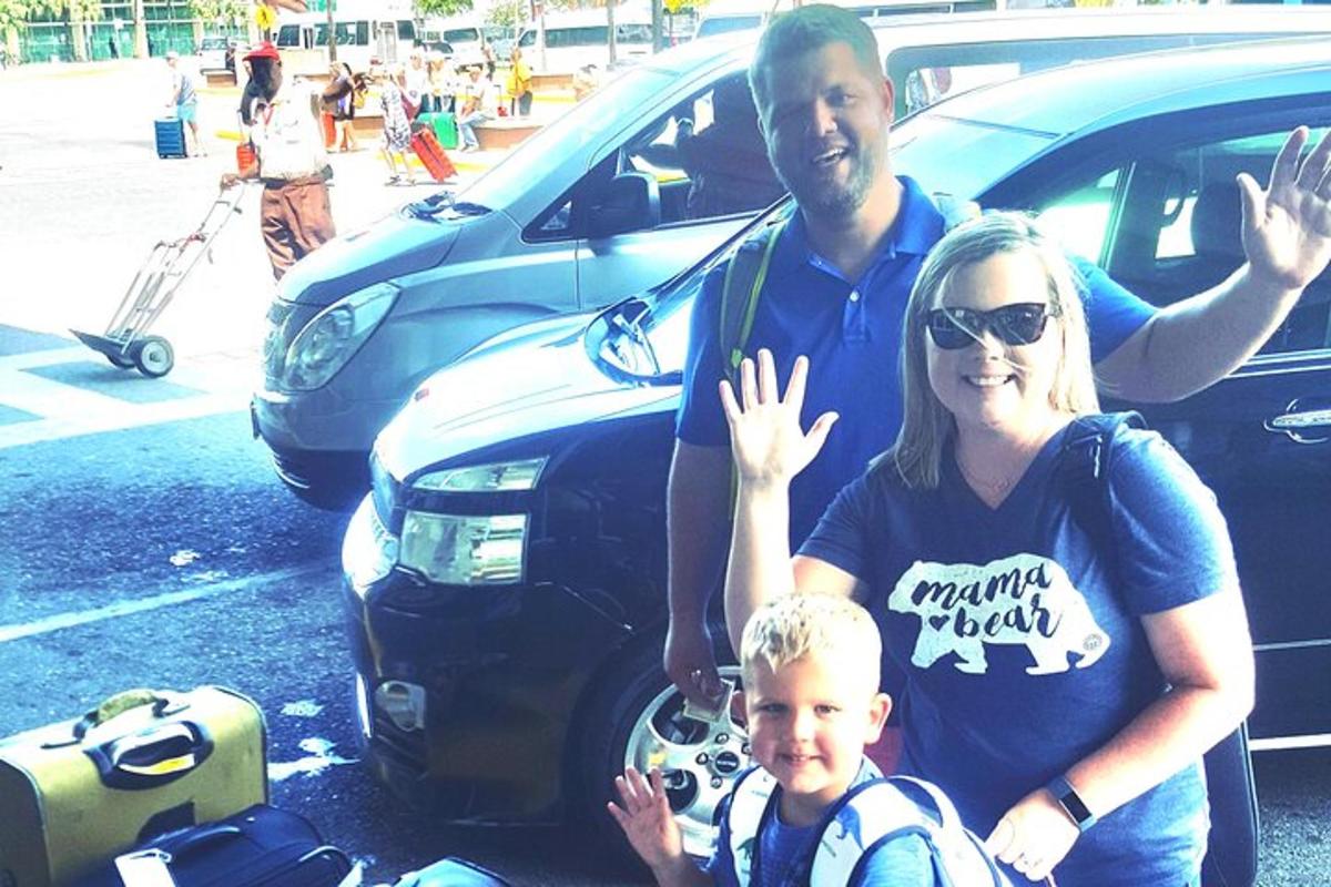 vyras, moteris ir vaikas stovi šalia automobilio