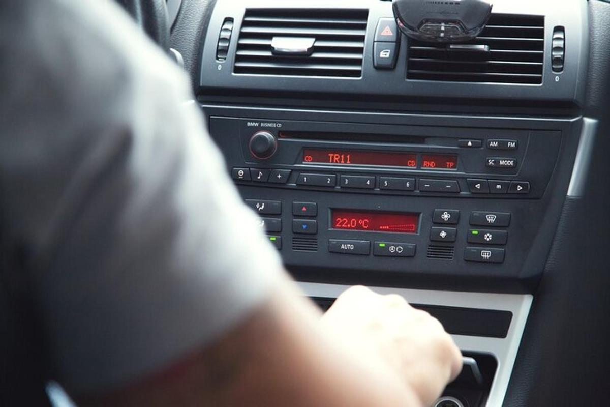 una persona alla guida di un'auto con un'autoradio