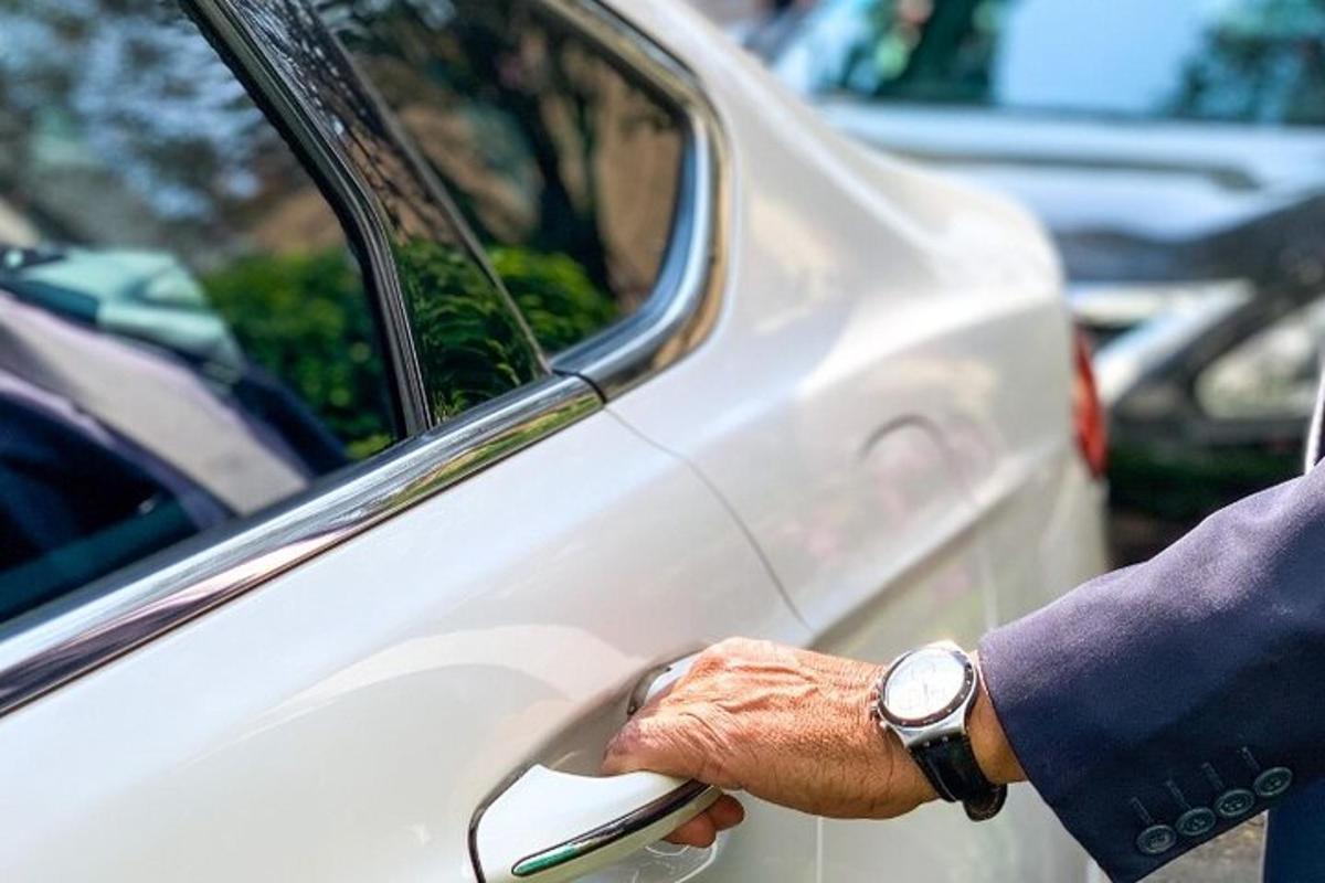a man holding the door of a white car
