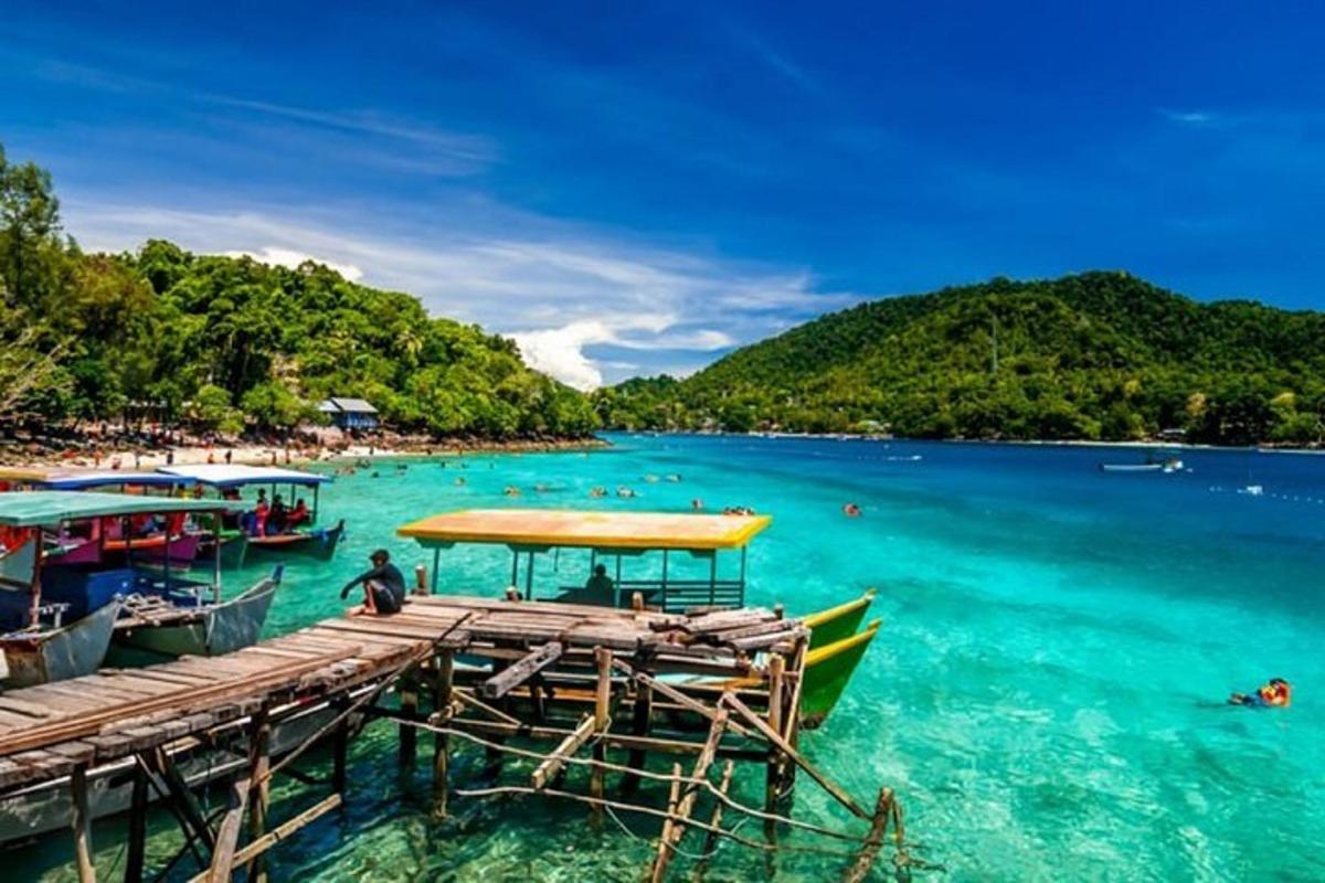 un molo con barche in acqua accanto a una spiaggia