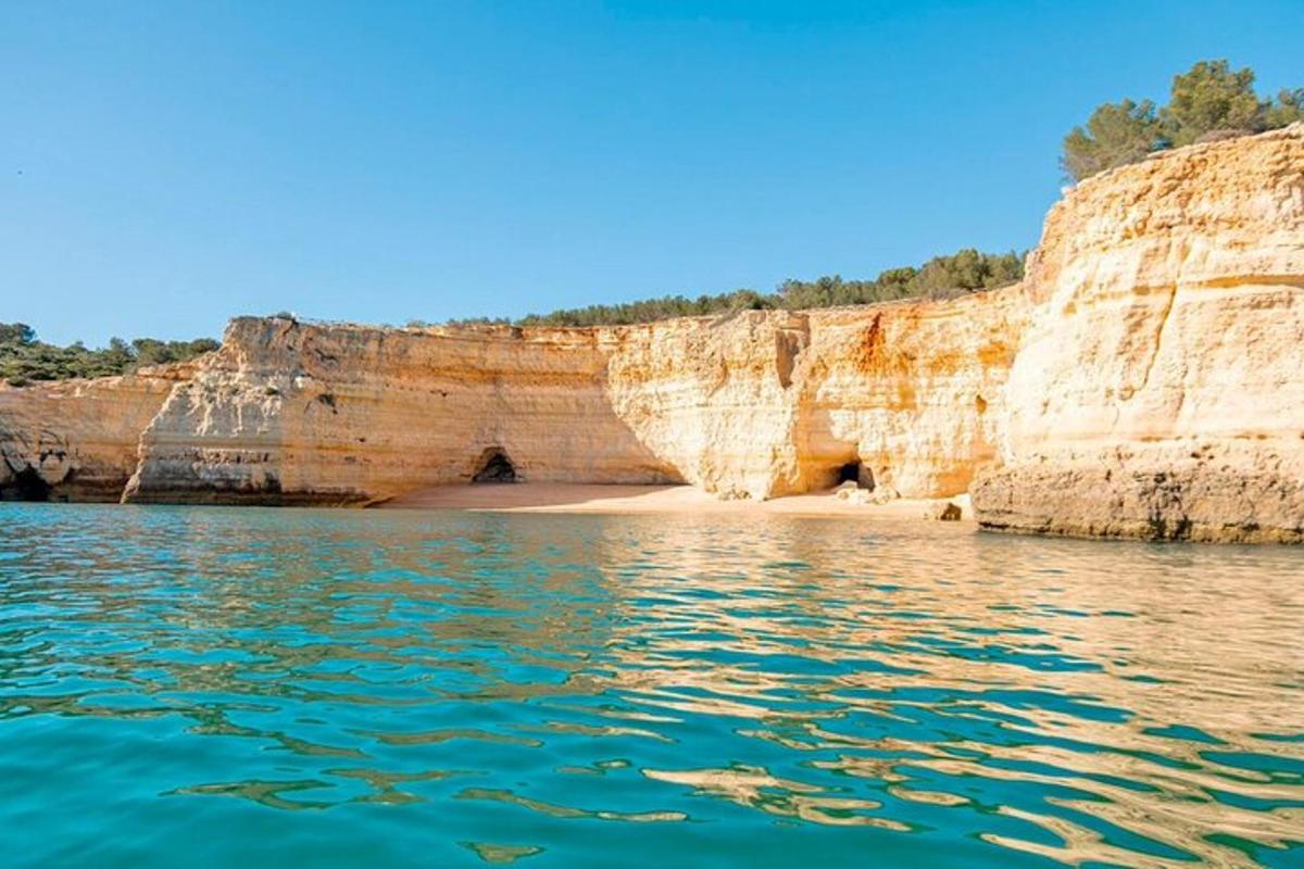 a view from the water of a beach and cliffs