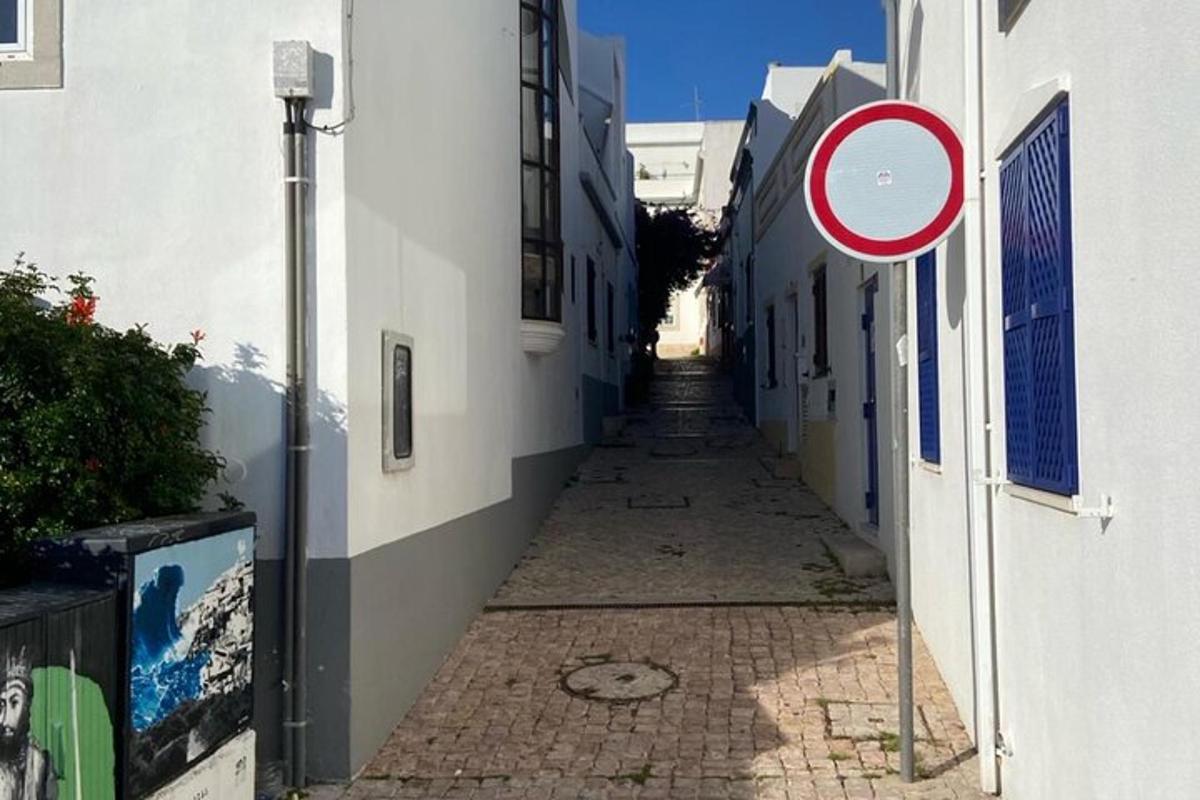 um beco com uma placa de rua ao lado de um prédio