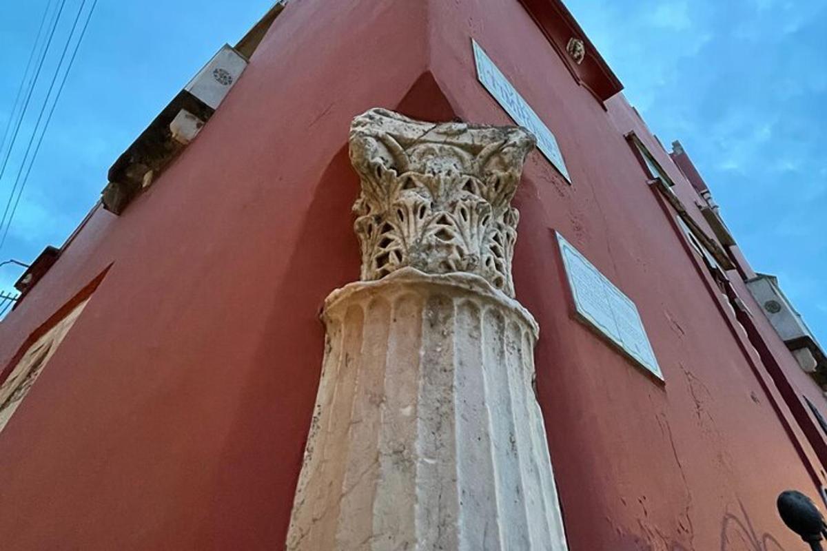 o coloană pe lateralul unei clădiri roșii