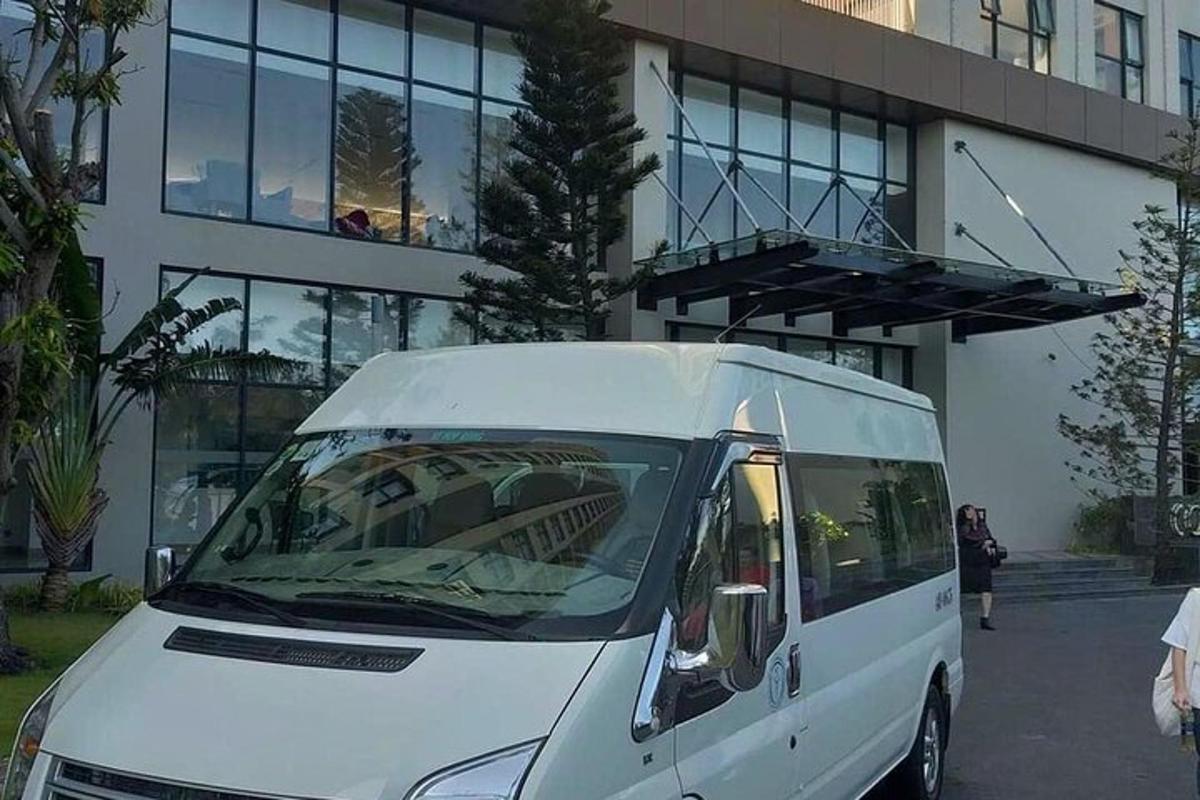 hvítur sendibíll lagður fyrir framan byggingu