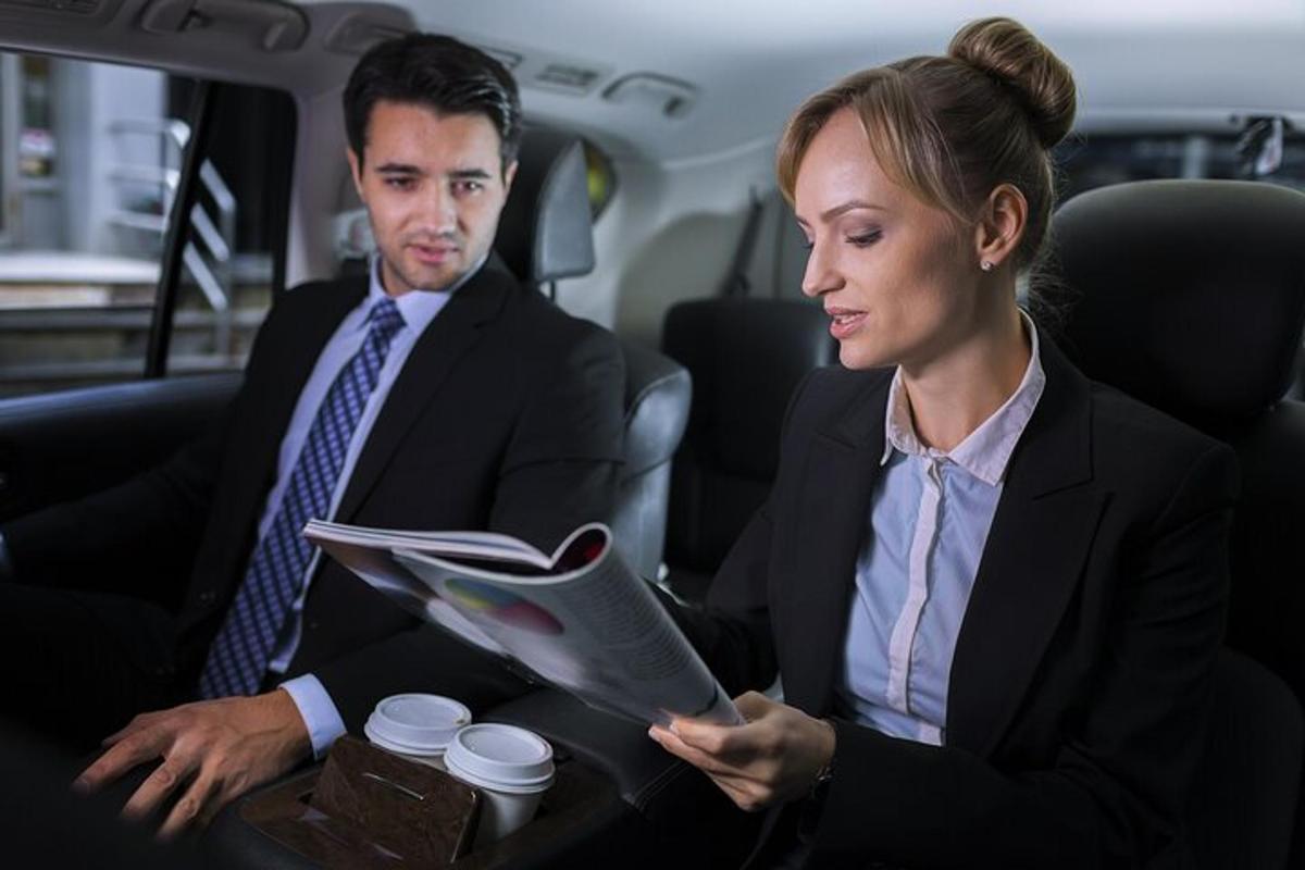 dos personas sentadas en el asiento trasero de un coche
