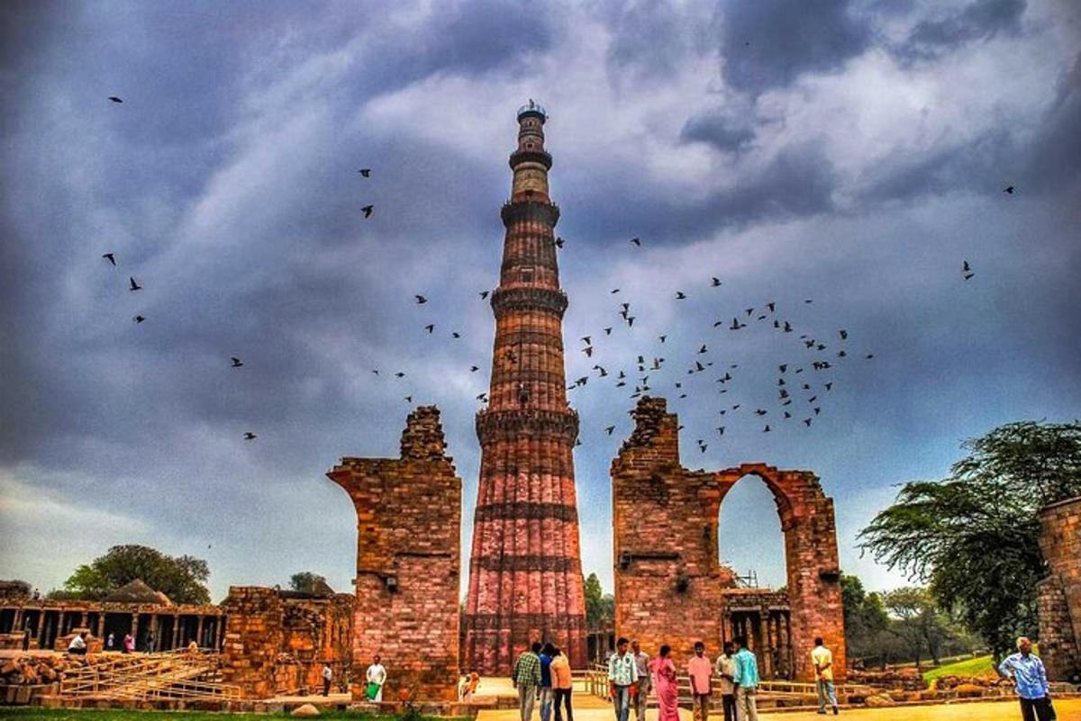 a group of people flying kites in front of a tower