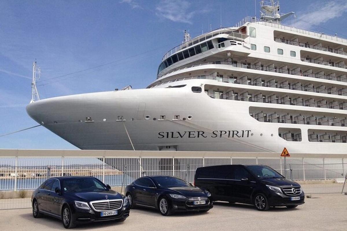 three cars parked in front of a cruise ship