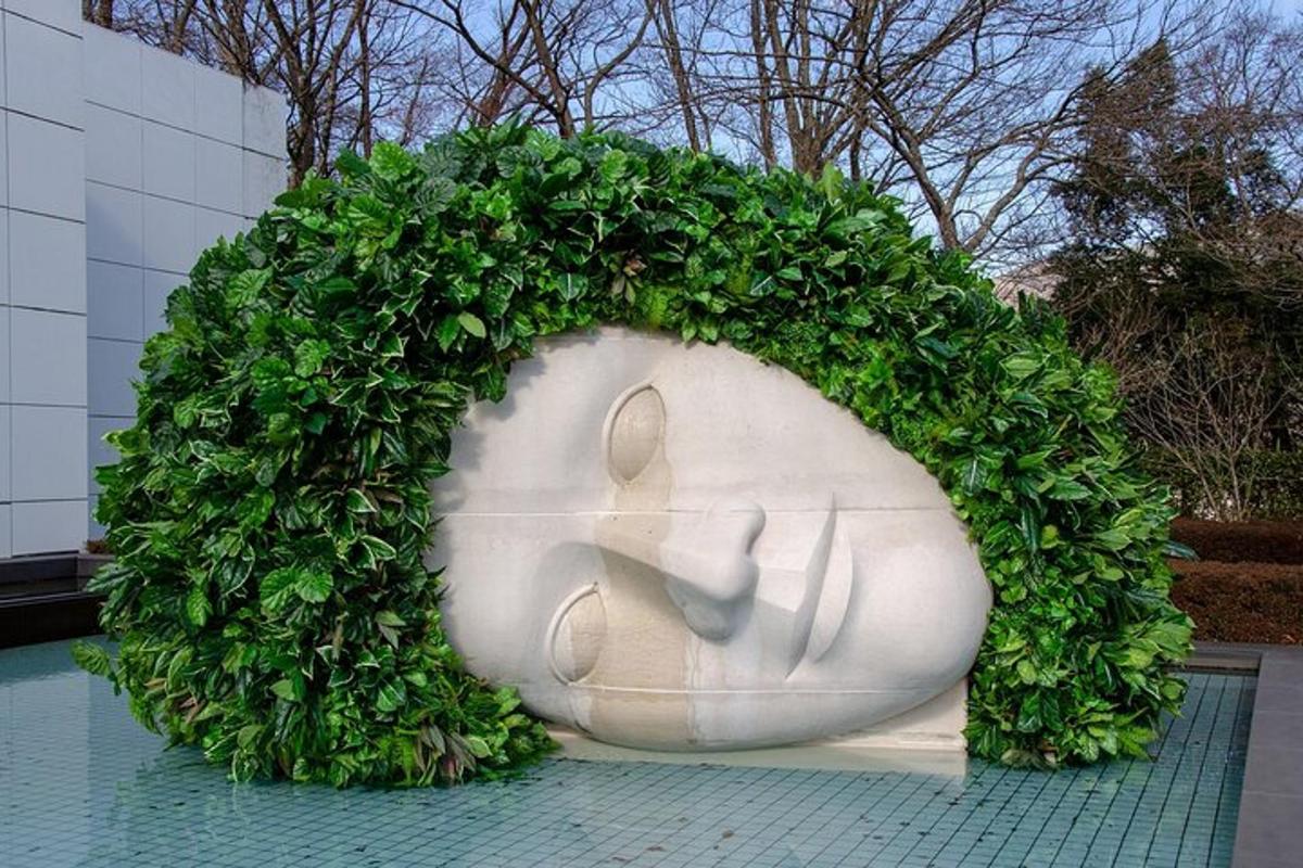 a statue with a green hedge around it