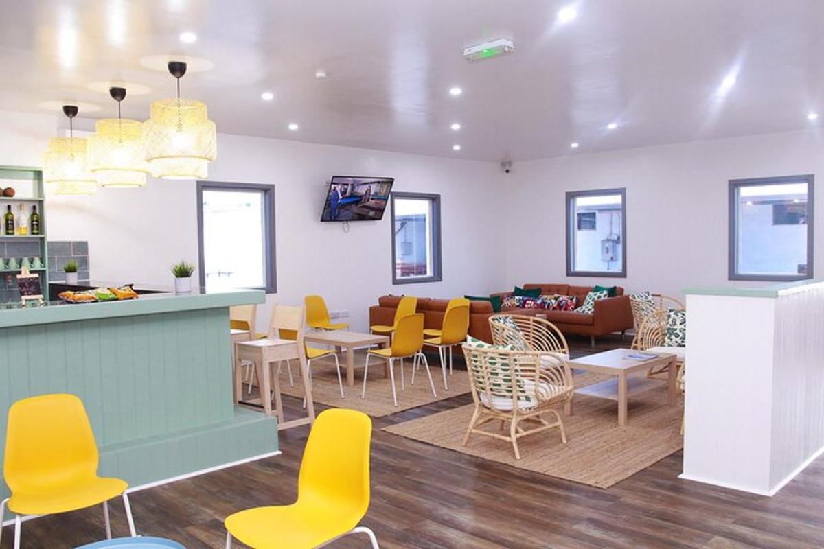 a waiting room with yellow chairs and a bar