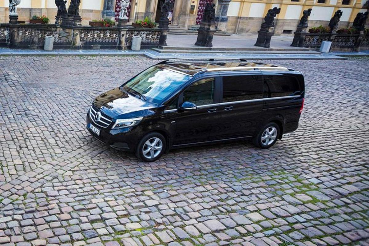 črn kombi parkiran na opečnati ulici