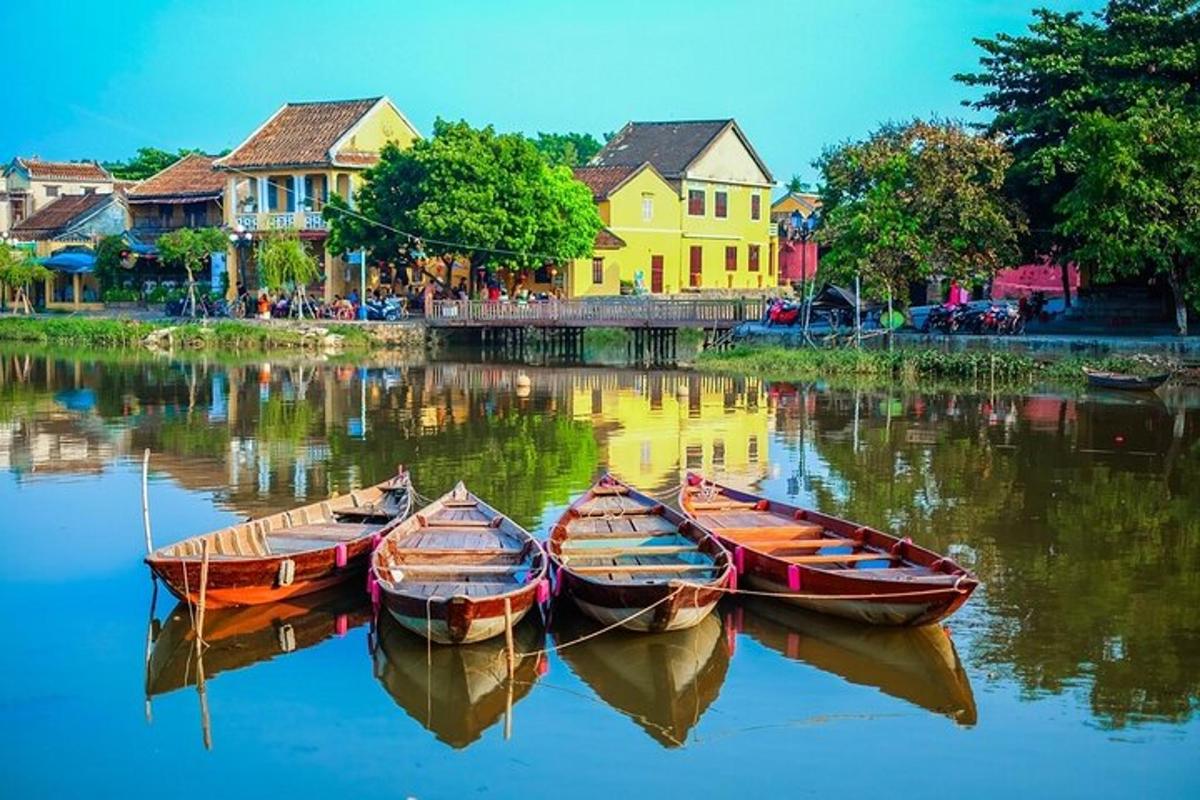 tři lodě stojící ve vodě před domy