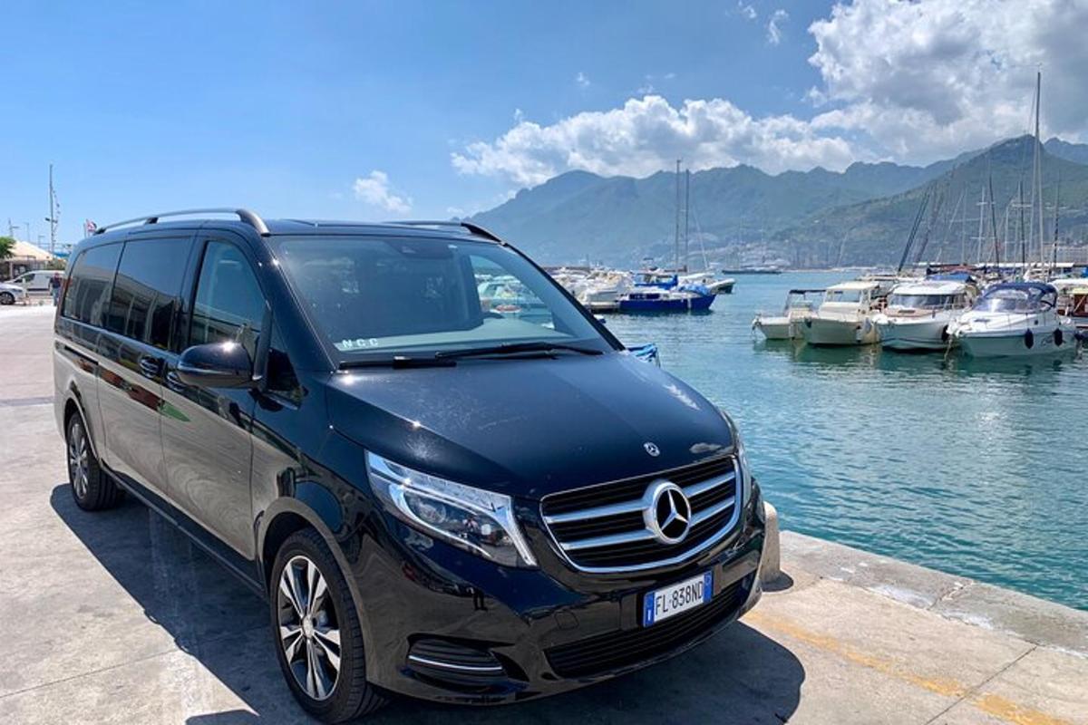 zils Mercedes Benz furgons, kas novietots blakus jahtu piestātnei