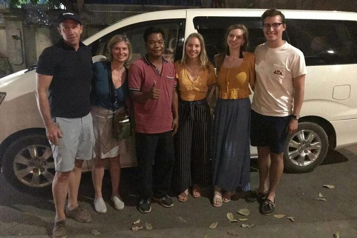 un grupo de personas de pie delante de un coche