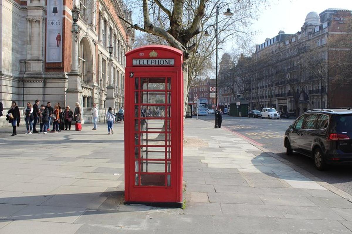 una cabina telefònica vermella al costat d'un carrer