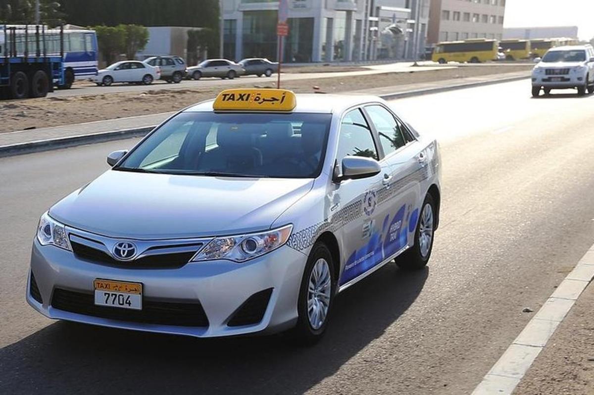 balta automašīna ar zīmi ceļa malā
