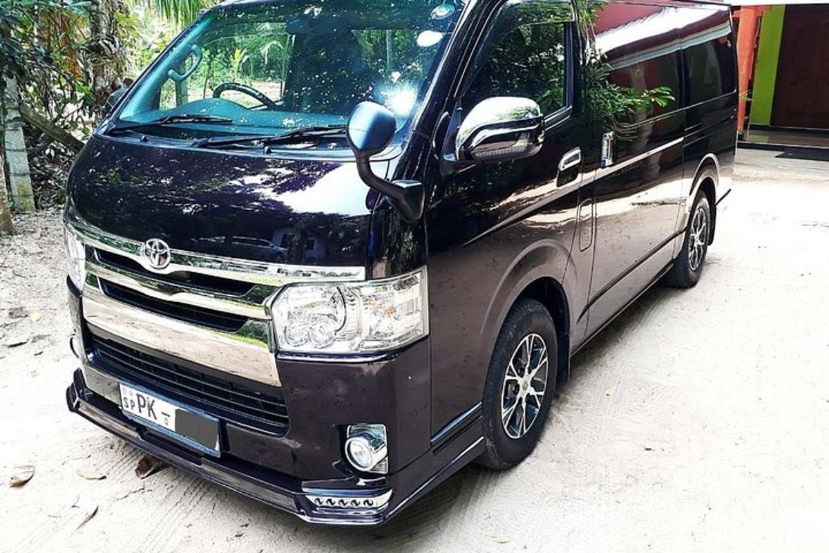 uma van preta estacionada em uma estrada de terra