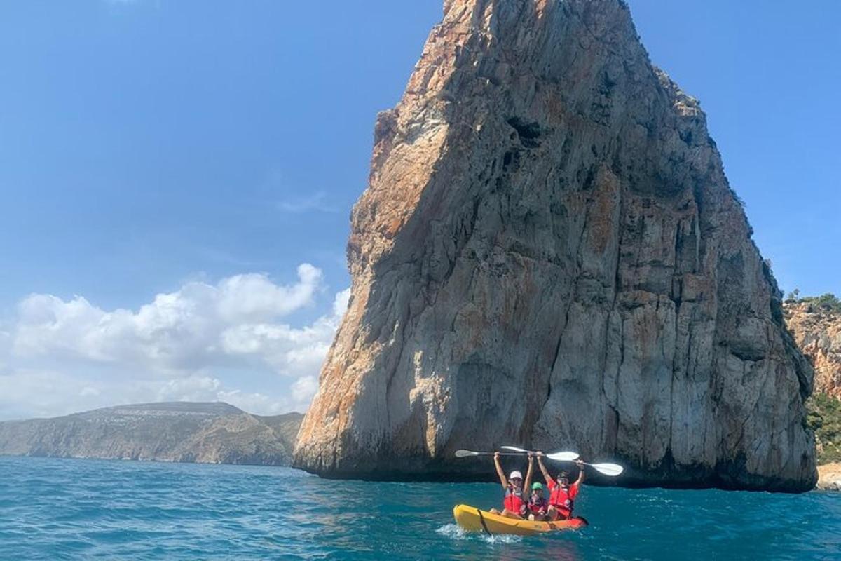 Un grupo de personas en una balsa en el agua cerca de una formación rocosa