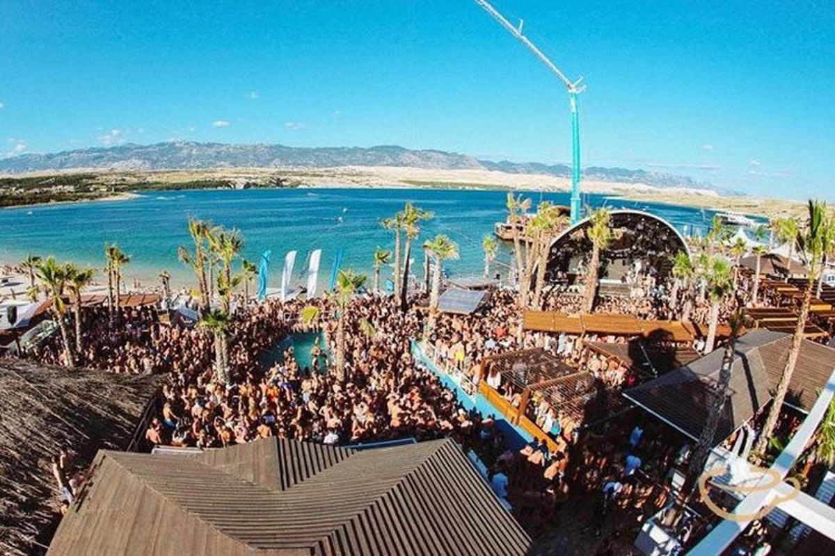 a large crowd of people standing around a beach
