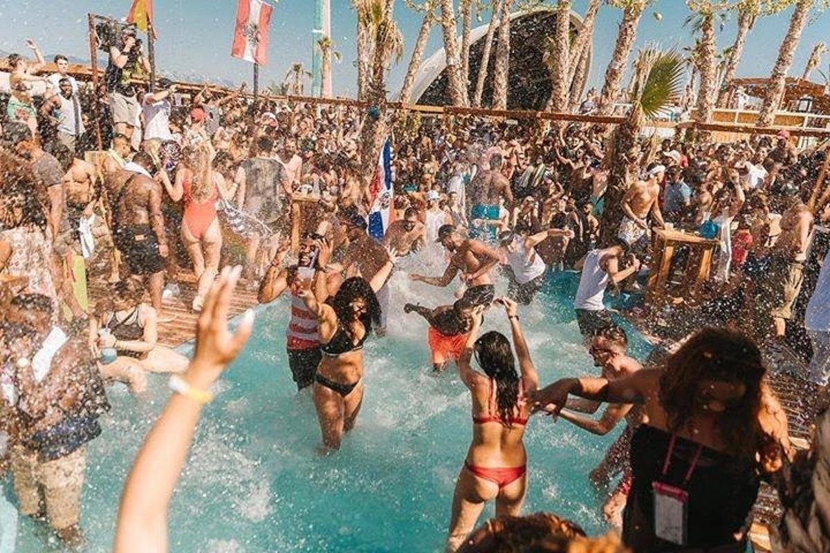 a crowd of people in the water at a party