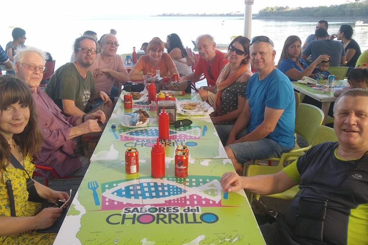 um grupo de pessoas sentadas ao redor de uma mesa com um bolo de aniversário
