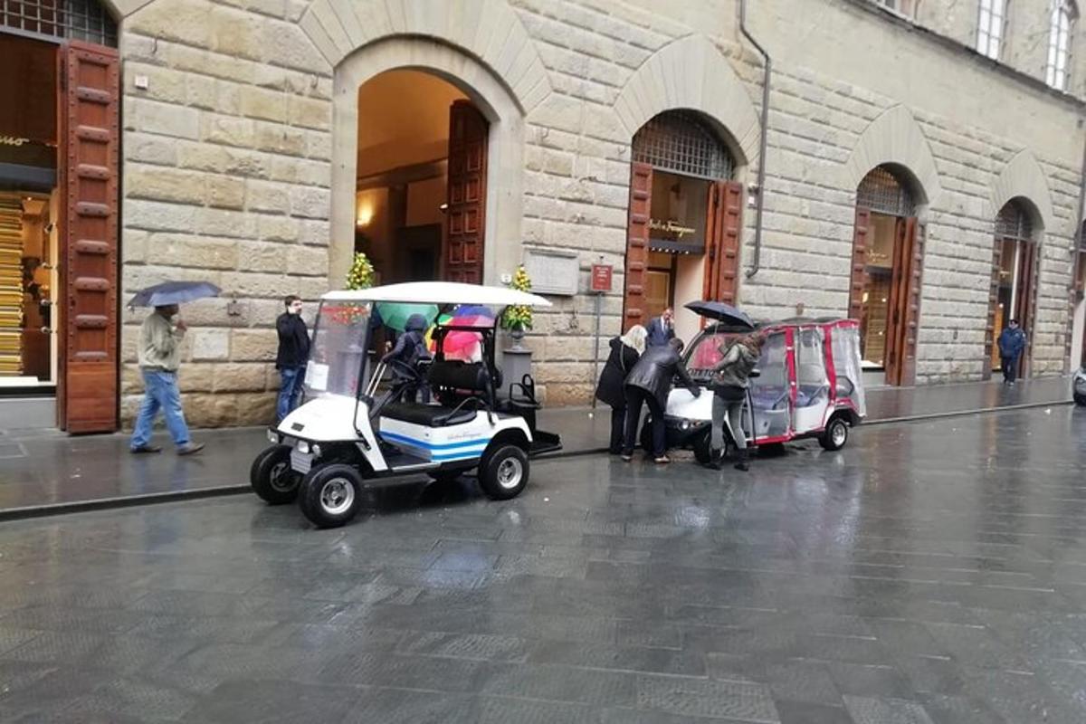 due golf cart parcheggiati fuori da un edificio sotto la pioggia