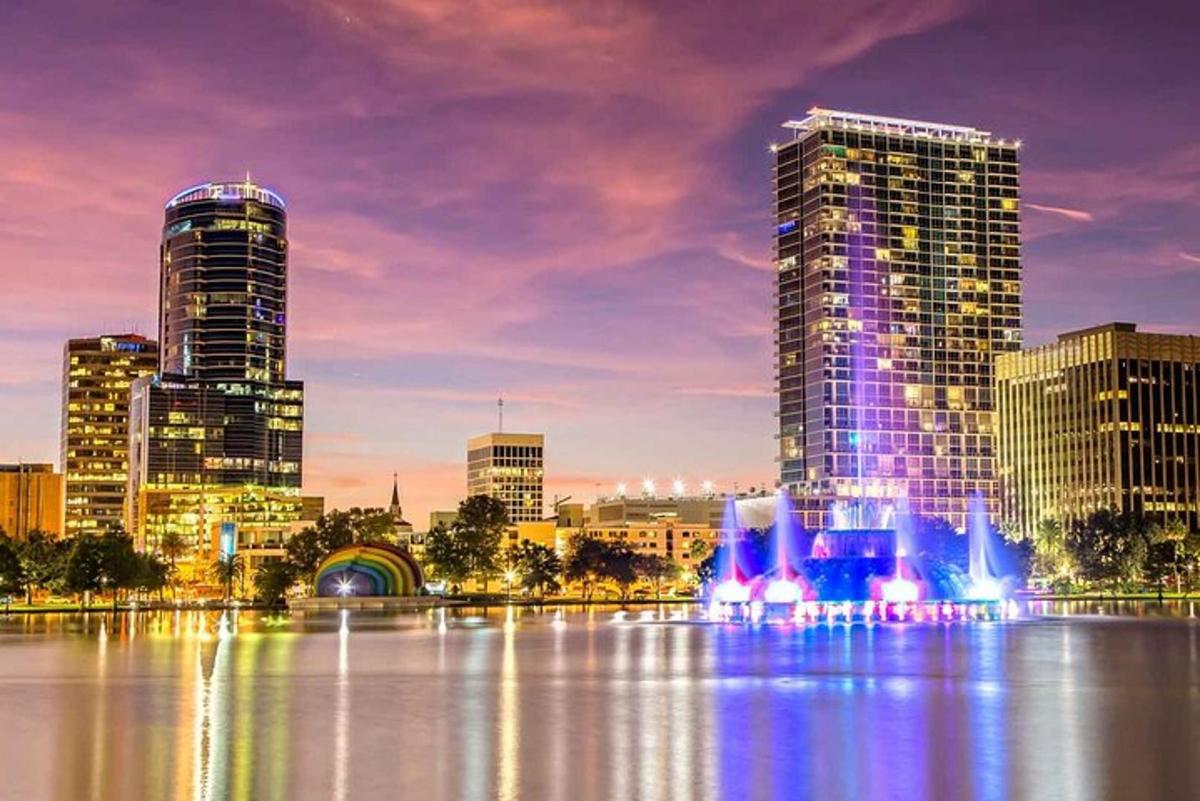 a city skyline with tall buildings and a fountain