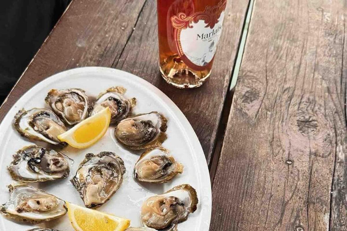 un piatto di ostriche su un tavolo con un drink