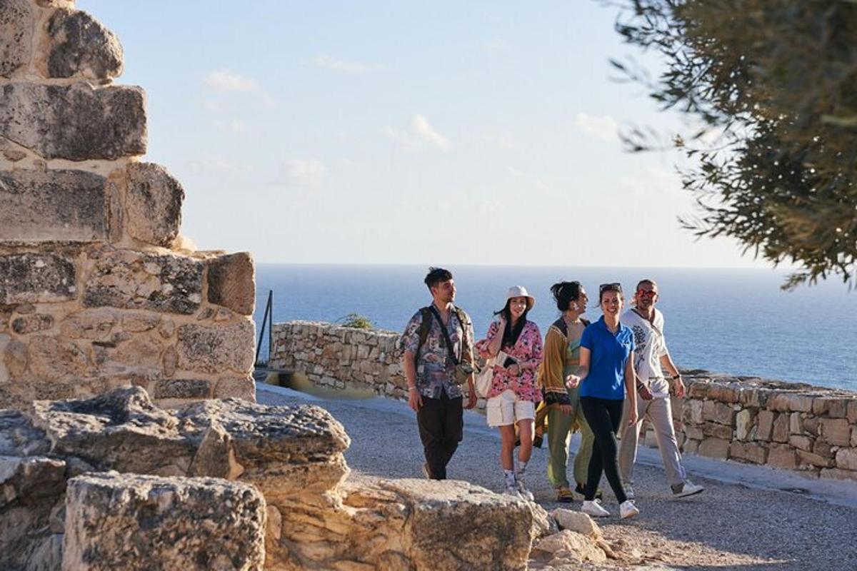 a group of people walking along a stone wall