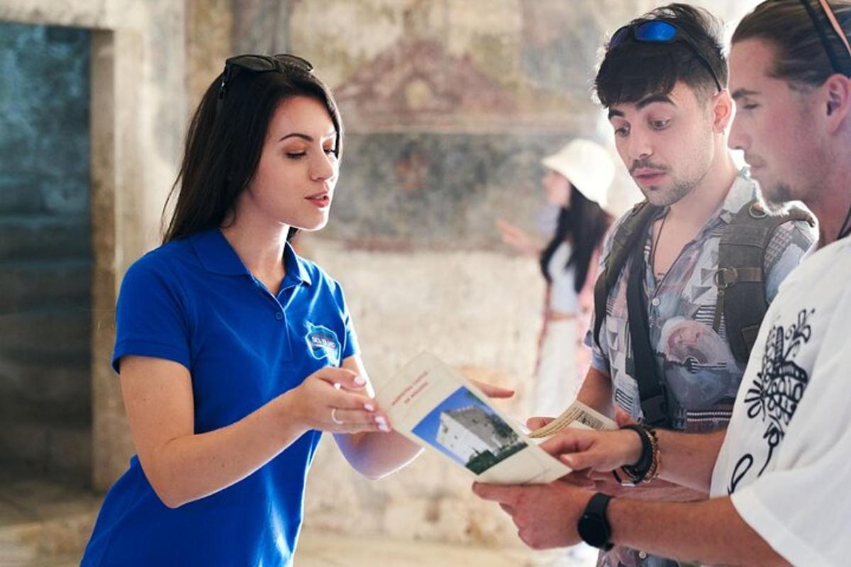 kobieta stojąca między dwoma mężczyznami trzymającymi książkę