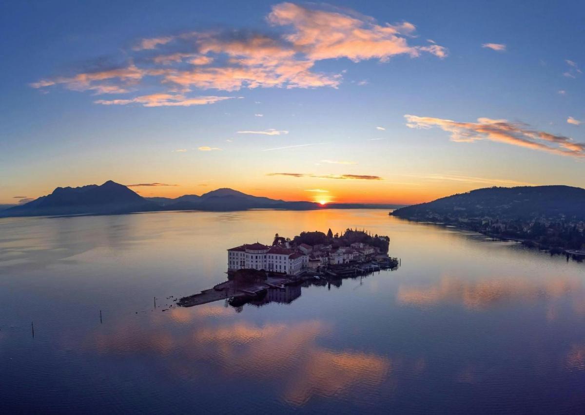 an island in the middle of a lake at sunset