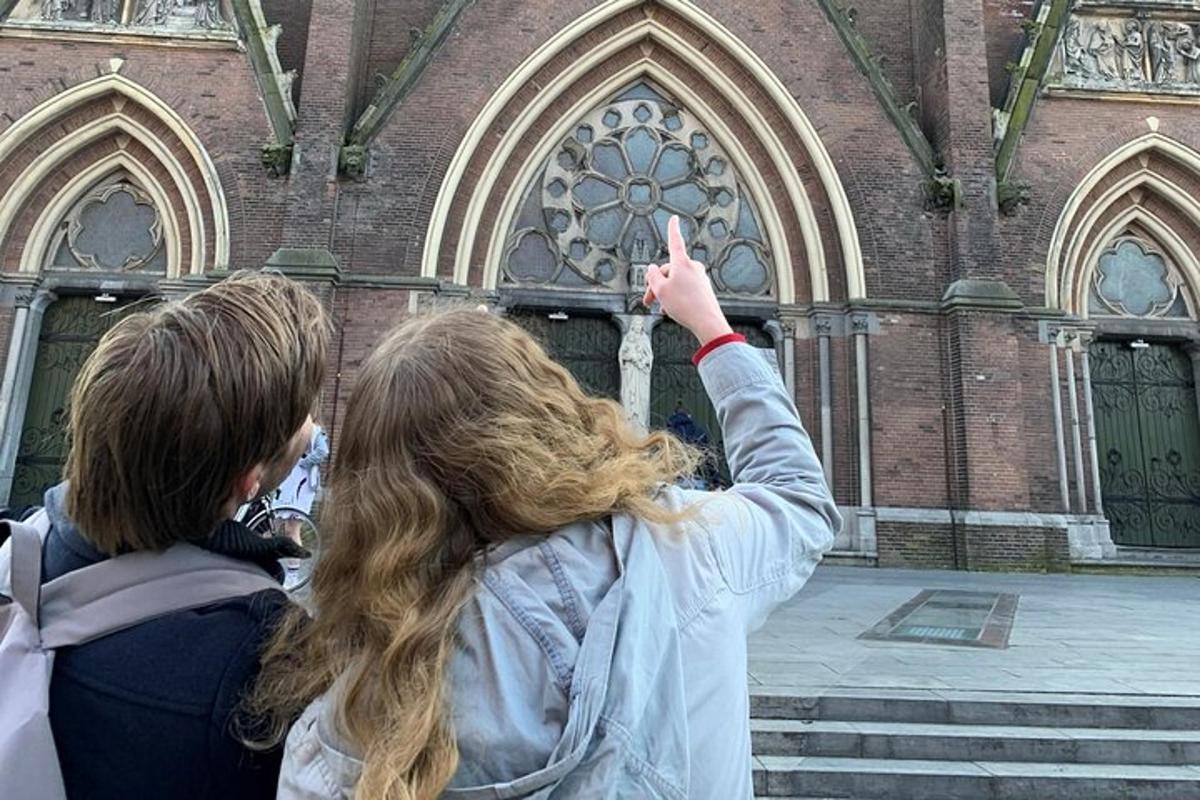 due ragazze in piedi davanti a una chiesa con il dito alzato in aria