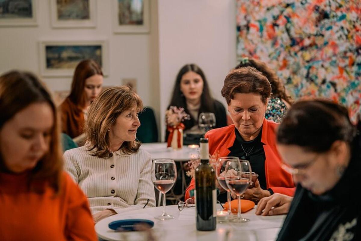 un gruppo di persone sedute a un tavolo con bicchieri di vino