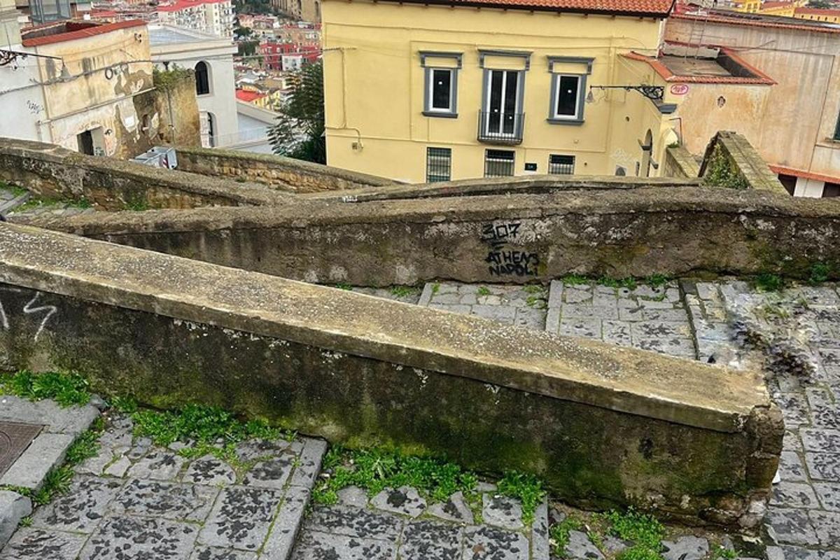 μια παλιά πέτρινη σκάλα με ένα κτίριο στο βάθος