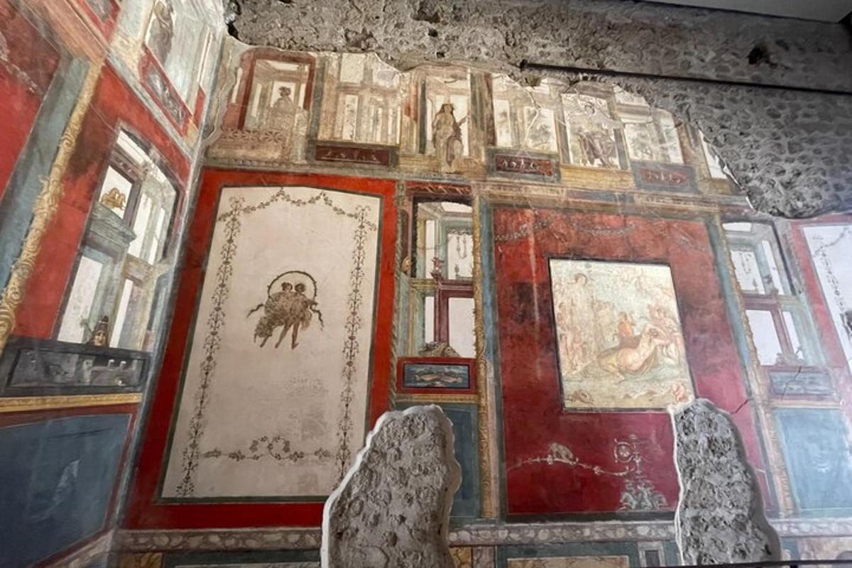 a room with a bunch of paintings on a wall
