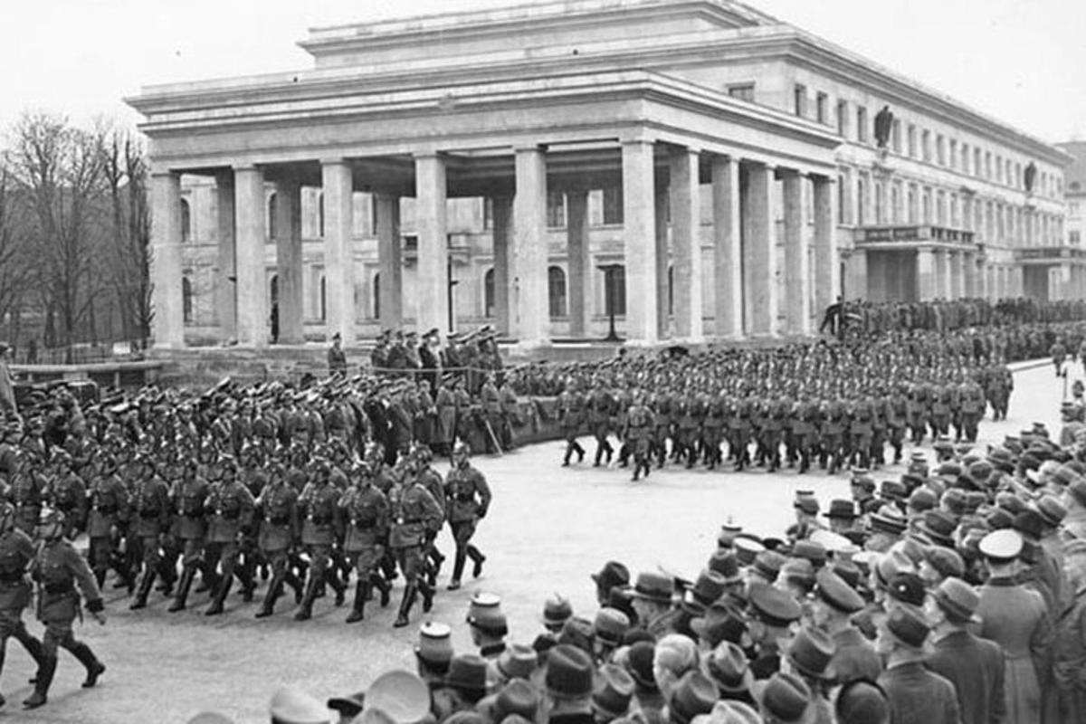 an old photo of a military parade in front of a building