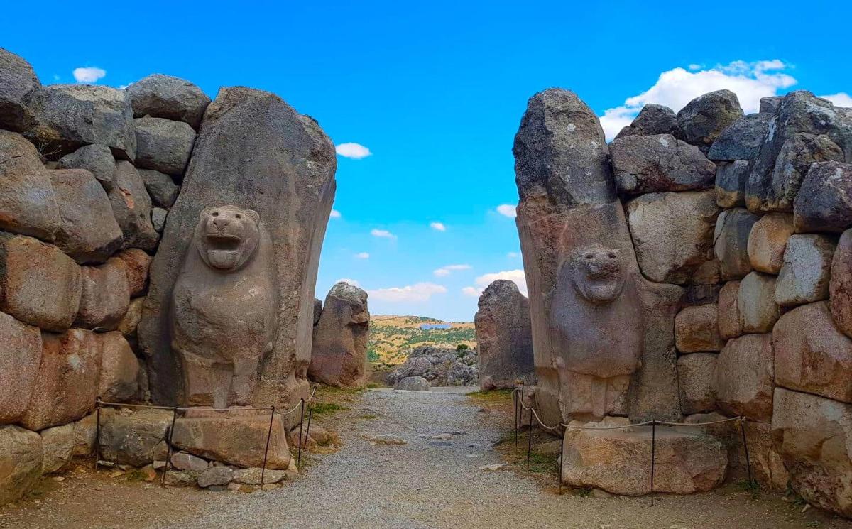 üzerinde yüzler bulunan bir grup taş heykel