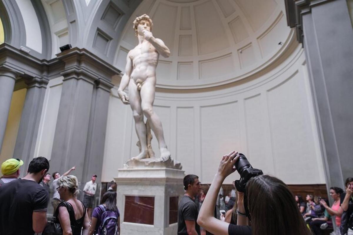 a group of people taking pictures of a statue in a museum