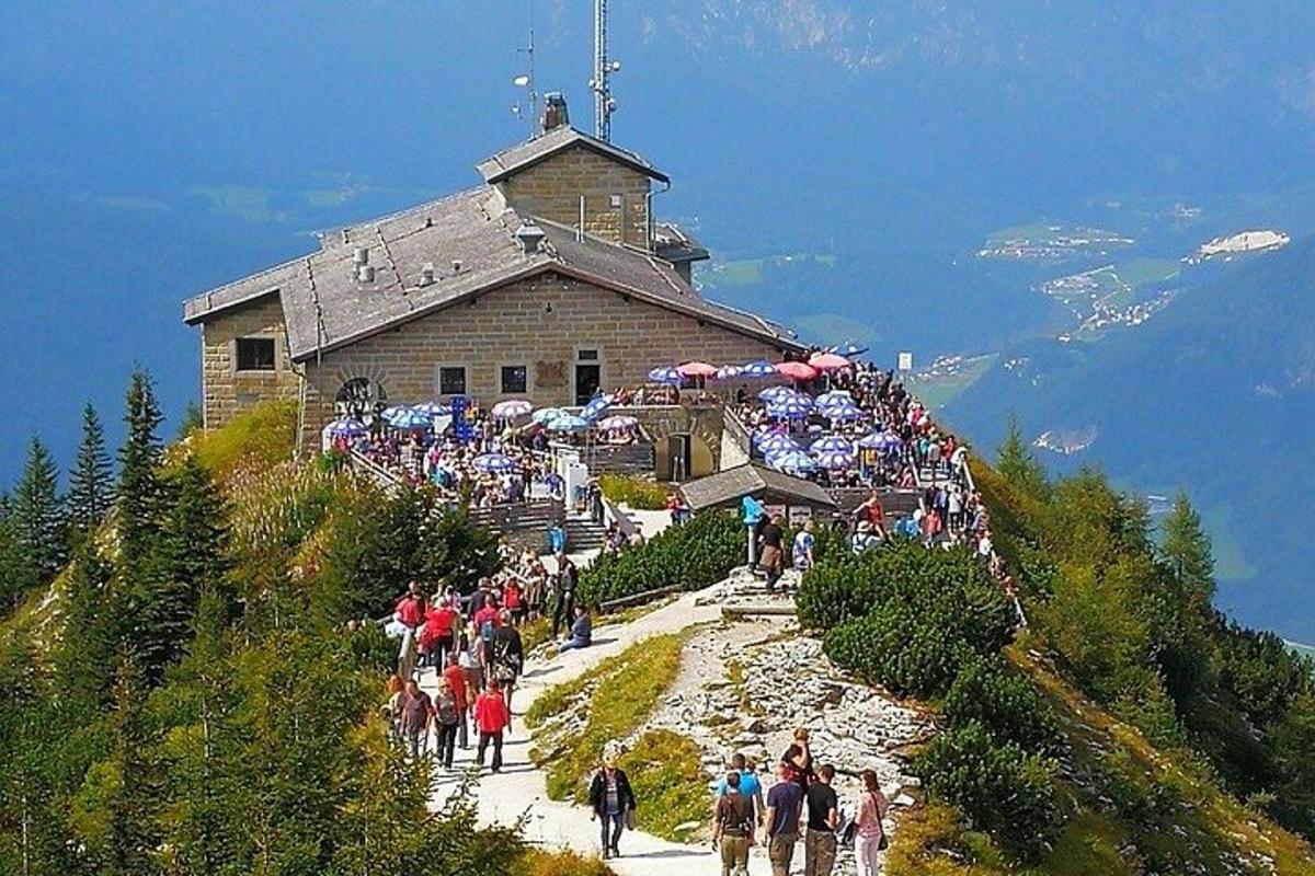 Un grupo de personas subiendo una montaña con un edificio.