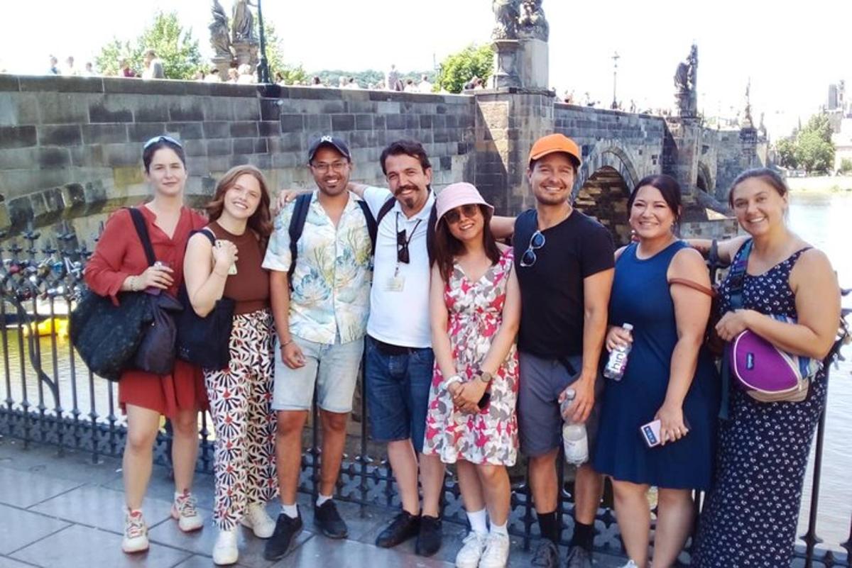 un grup de oameni care pozează pentru o fotografie în fața unui pod
