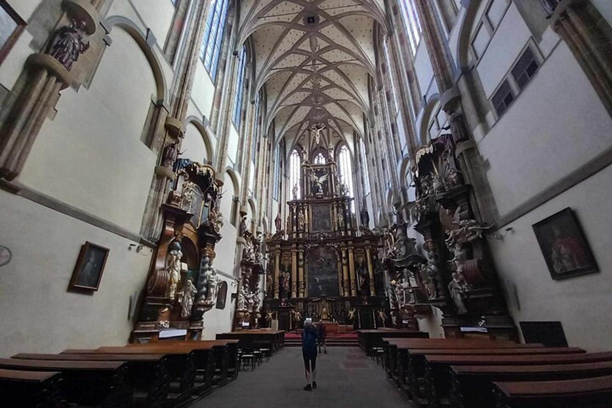 osoba prechádzajúca cez veľký kostol s lavicami