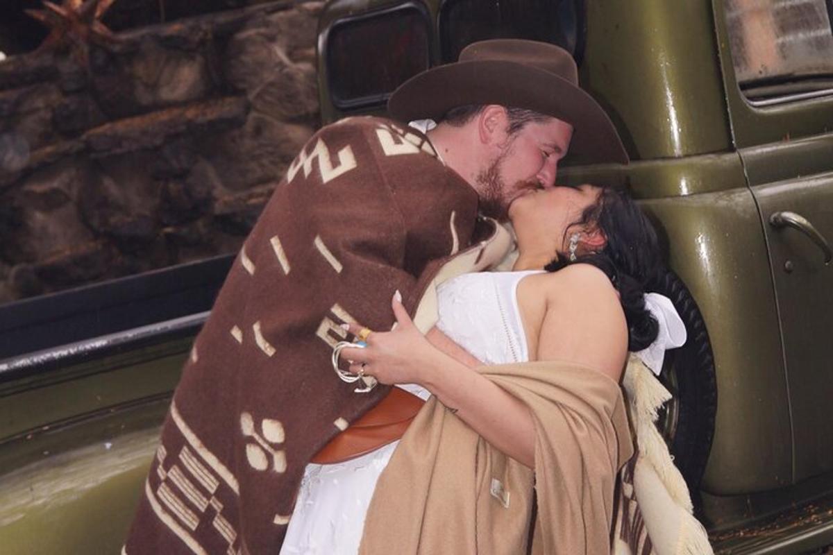un uomo e una donna vestiti in costume in piedi accanto a un camion verde