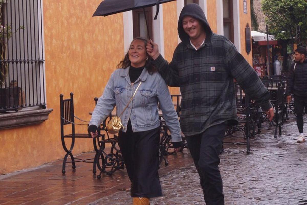 un uomo e una donna camminano lungo una strada sotto la pioggia