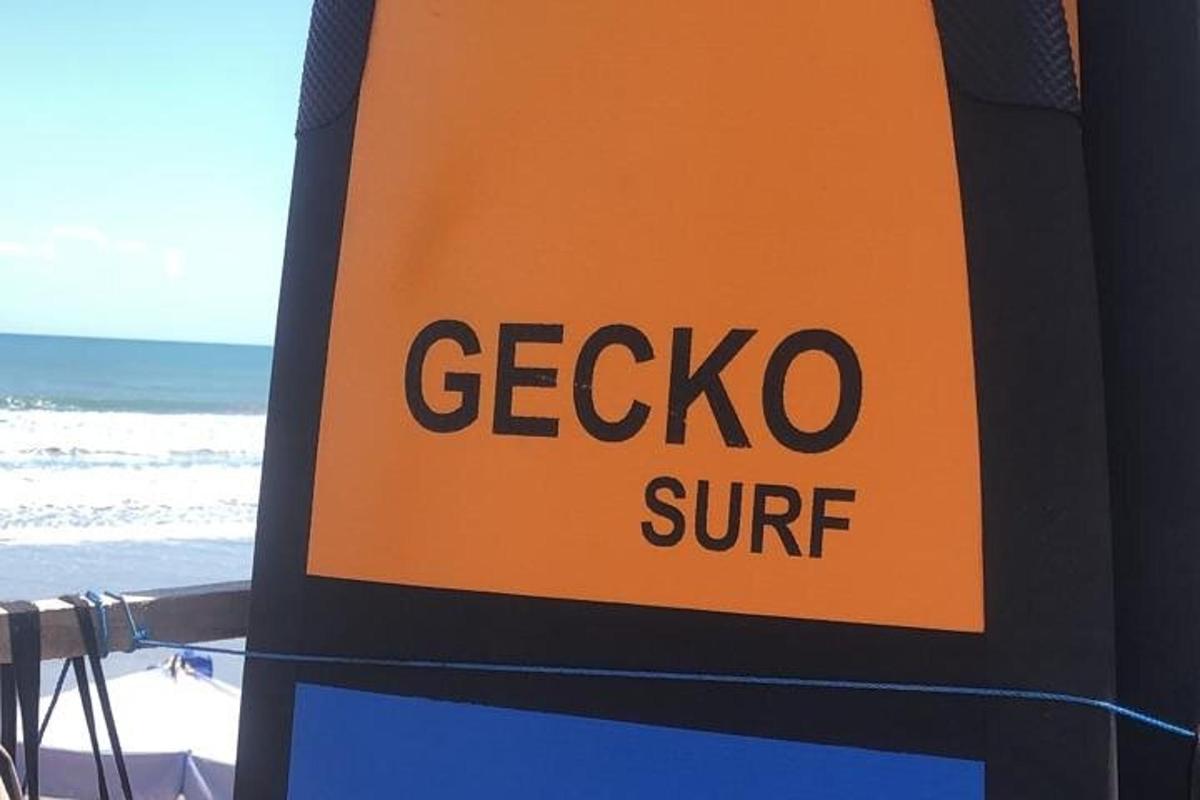 μια πινακίδα για ένα κατάστημα grecio surf στην παραλία